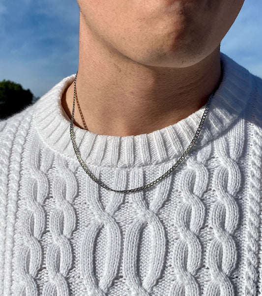 Este collar de acero inoxidable para hombre tiene un diseño minimalista y robusto. La cadena de acero inoxidable le confiere un aspecto resistente y moderno. La superficie pulida del collar refleja la luz, creando un efecto llamativo y masculino. Es una pieza versátil que puede complementar tanto atuendos casuales como formales